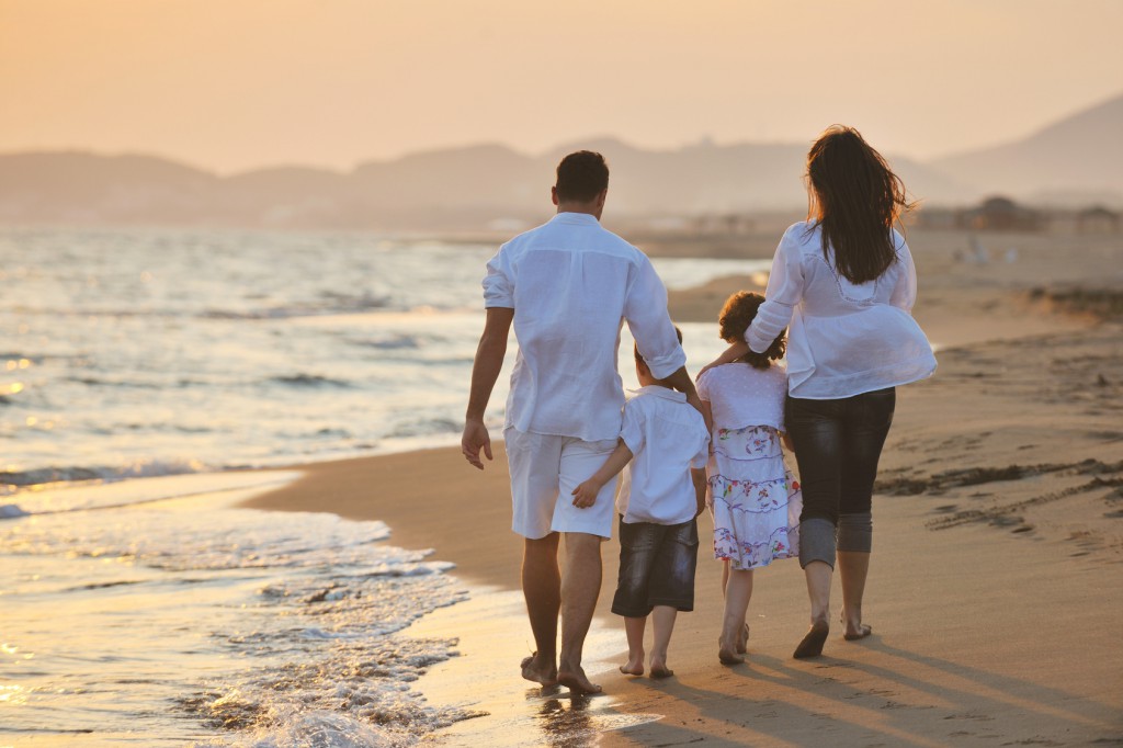 happy young family have fun on beach at sunset